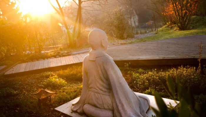 A statue of a meditating monk sits in our garden.
